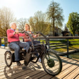 zwei Radfahrer auf einem Tandem nebeneinander in der Natur