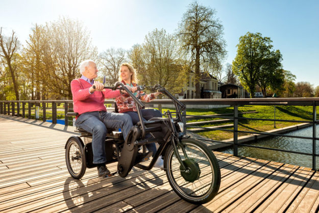 zwei Radfahrer auf einem Tandem nebeneinander in der Natur